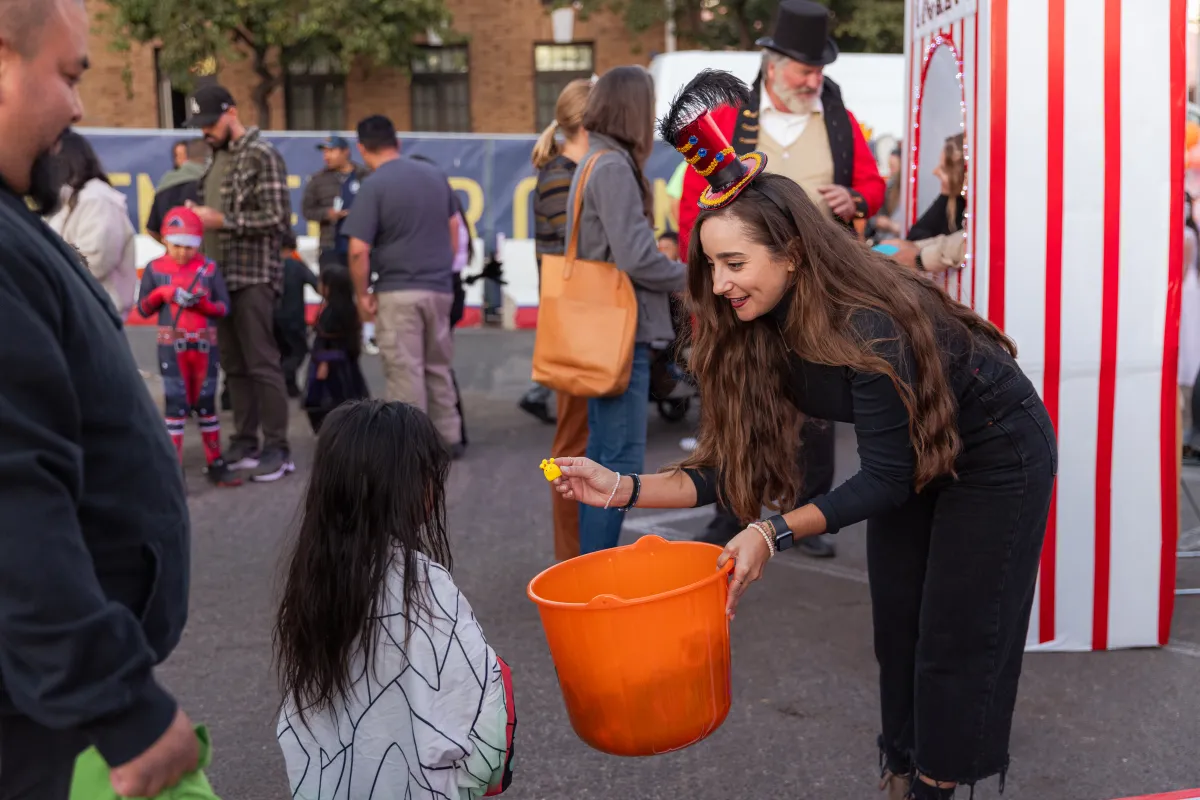 Staff person handing out candy at Trunk or Treat