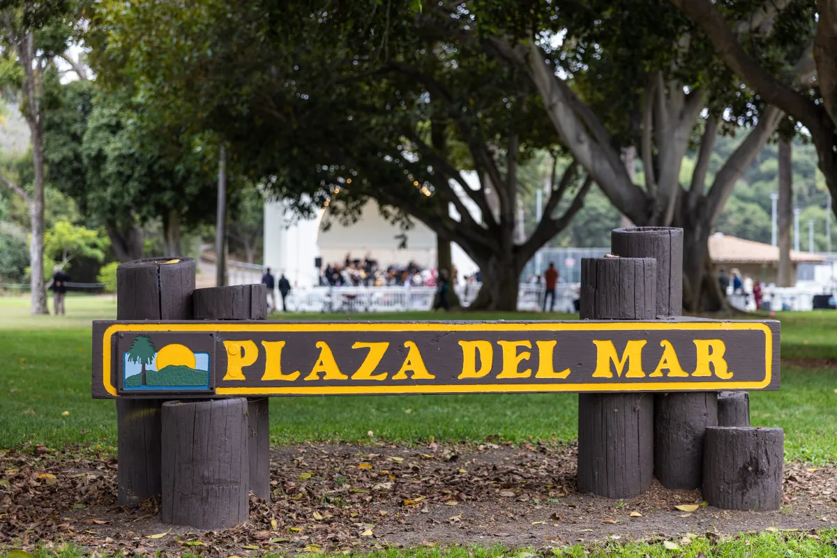 Plaza Del Mar park sign with performance at the Band Shell in the background