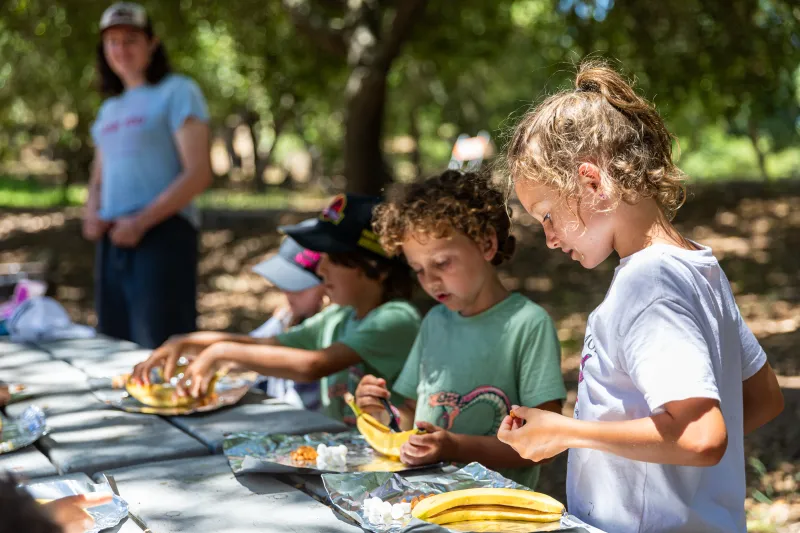 Campers work on a project together with a counselor looking on