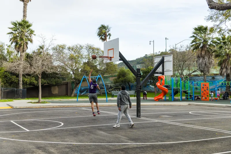 Community members play basketball on the new court at Westside Neighborhood Center