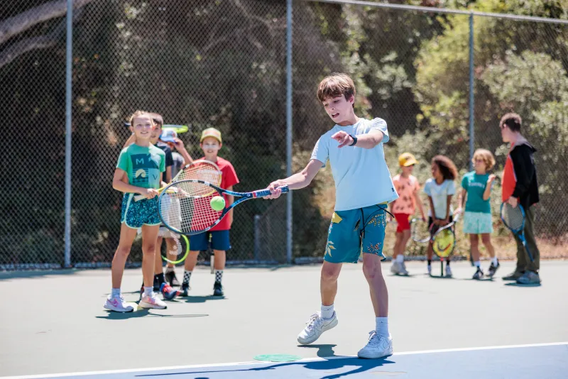 Tennis camper returns a serve at Tennis Camp